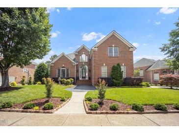 Beautiful brick two-story home featuring a landscaped front yard and inviting entranceway at 12140 Pawleys Mill Cir, Raleigh, NC 27614