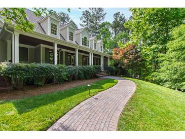 Inviting traditional home with a charming brick walkway and a beautifully landscaped front yard at 131 Lavinia Ln, Chapel Hill, NC 27516