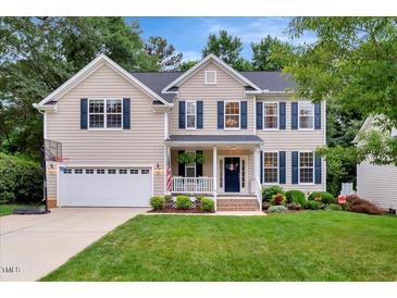 Charming two-story home with a well-manicured lawn, blue shutters, and a welcoming front porch at 201 Forbes Rd, Wake Forest, NC 27587