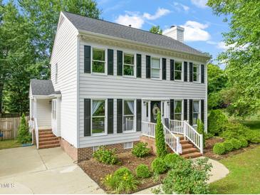 Charming two-story home with white siding, black shutters, brick foundation and well-manicured landscaping at 21 Cedar Hill Dr, Durham, NC 27713