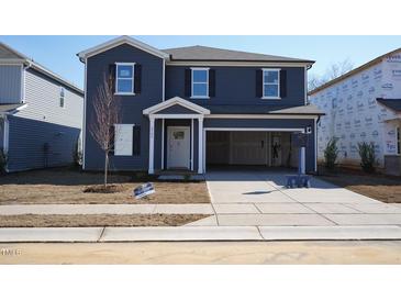 Charming two-story home with blue siding, open garage, and landscaped front yard at 2106 Cherry Creek Road Rd, Haw River, NC 27258