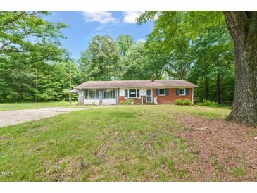 Charming one-story home with a brick exterior, complemented by lush green lawn and mature trees at 211 Cool Spring Rd, Durham, NC 27713