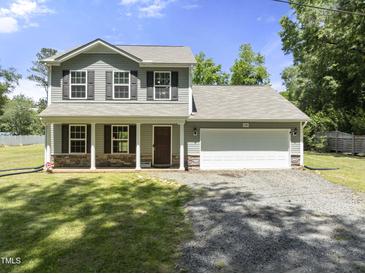 Charming two-story home featuring a welcoming front porch, a two-car garage, and a well-maintained lawn at 218 Mason Rd, Durham, NC 27712