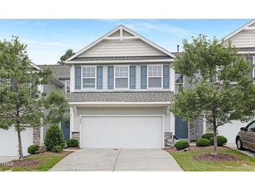 Charming two-story townhome with a two-car garage, gray siding, blue shutters, and a well-manicured lawn at 222 Explorer Dr # 271, Morrisville, NC 27560