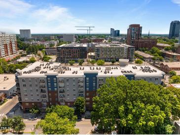 A beautiful aerial view of a modern apartment building surrounded by mature trees and a vibrant cityscape at 222 Glenwood Ave # 714, Raleigh, NC 27603