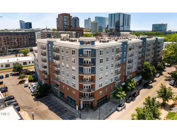 Corner view of a condo complex in an urban neighborhood featuring brick and gray facade with balconies at 222 Glenwood Ave # 714, Raleigh, NC 27603