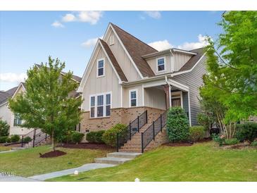 Inviting two-story home with a beautifully landscaped front yard and charming architectural details at 2837 Milano Ave, Apex, NC 27502