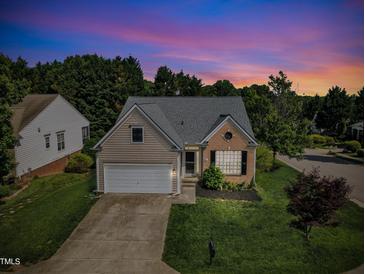 Charming home featuring a well-maintained yard, attached garage, and classic architectural details under a vibrant sunset at 3400 Secretariat Way, Raleigh, NC 27614