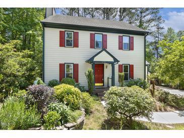 Charming two-story home with red shutters, landscaped yard, and forest backdrop at 5704 Cholderton Ct, Raleigh, NC 27604
