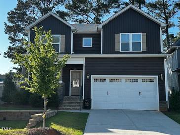 Charming two-story home with a modern dark exterior, a two-car garage, and a well-maintained front yard at 809 Trinity Park Dr, Wake Forest, NC 27587