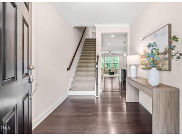 Inviting entryway with hardwood floors, staircase, decor table, and access to the living areas with bright natural light at 1049 Lakebrink Dr, Morrisville, NC 27560