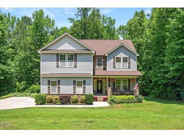 Charming two-story home with manicured lawn and landscaping at 110 Lexington Ave, Zebulon, NC 27597