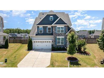 Inviting two-story home with blue and gray facade, manicured lawn, and a spacious driveway leading to a two-car garage at 123 Gunderson Ln, Garner, NC 27529