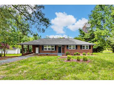 Charming brick home with a covered carport and well-maintained front yard, exuding curb appeal at 1592 Boone Rd, Elon, NC 27244