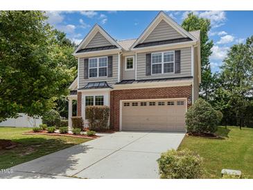 Charming two-story home featuring gray siding, brick accents, a two-car garage, and a well-maintained front yard at 233 Hammond Wood Place, Morrisville, NC 27560