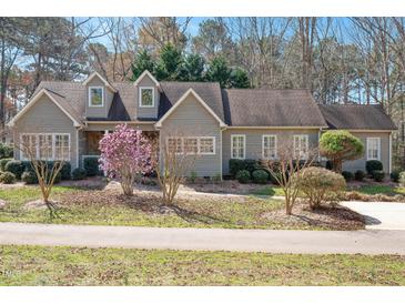 Charming single-story home with a manicured lawn, flowering trees, and gray siding at 2412 Mollynick Lane Ln, Wake Forest, NC 27587