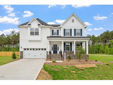 Inviting two-story home with a two-car garage, classic architectural design, and a well-manicured front yard at 60 Bold Dr, Youngsville, NC 27596