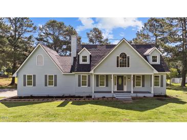 Charming two-story home with light blue siding, dark shutters and a landscaped front yard at 620 Richardson Rd, Zebulon, NC 27597