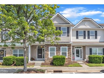 Charming townhome with stone accents, manicured bushes, and a tree-lined street at 711 Keystone Park Dr # 7, Morrisville, NC 27560