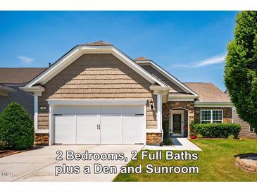 Charming home featuring shake siding, stone accents, a two-car garage, and manicured lawn at 740 Blackfriars Loop, Cary, NC 27519