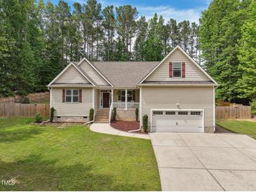 Charming home with a well-manicured lawn, a two-car garage and delightful curb appeal at 105 Old Barn Way, Wendell, NC 27591