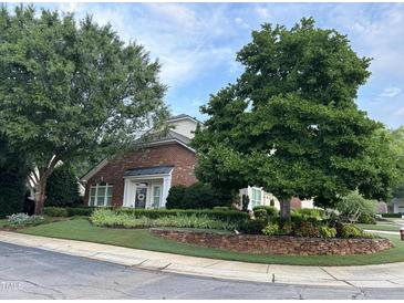 Charming brick home featuring meticulously manicured front yard and mature trees at 12221 Orchardgrass Ln, Raleigh, NC 27614