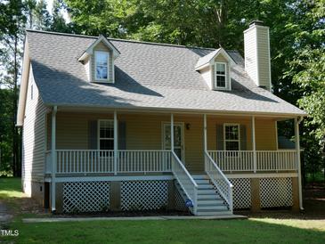 Charming two-story home with a welcoming front porch, dormer windows, and manicured lawn at 129 Clark Ct, Youngsville, NC 27596