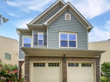 Charming two-story home with a stone-clad garage and blue horizontal siding at 2072 Tanners Mill Dr, Durham, NC 27703