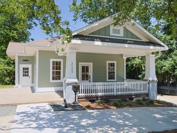 Charming exterior featuring a cozy porch, white railing, and manicured landscaping at 2106 University Dr, Durham, NC 27707