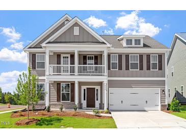Charming two-story home boasts a covered porch, two-car garage, and manicured lawn at 2178 Pink Peony Circle Lot 167 Cir, Durham, NC 27703