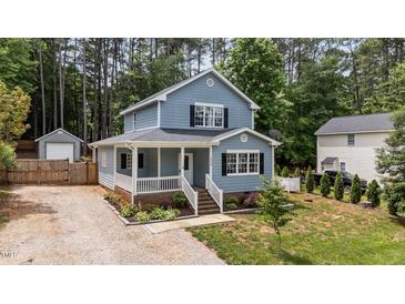 Charming two-story home boasts a welcoming front porch, complemented by verdant landscaping and natural surroundings at 225 Sacred Fire Rd, Louisburg, NC 27549