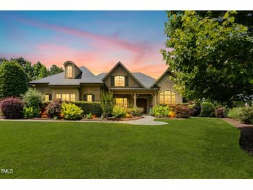 Beautiful brick home featuring a manicured lawn, professional landscaping, and inviting front porch at 238 Michelangelo Way, Cary, NC 27518