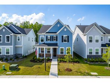 Charming two-story home with blue siding, black shutters, landscaped yard, and inviting front porch at 279 Edge Of Auburn Blvd, Raleigh, NC 27610