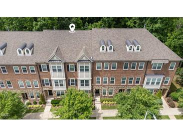 Beautiful brick townhome featuring dormer windows and professionally landscaped front yard at 3109 Stockdale Dr, Raleigh, NC 27609
