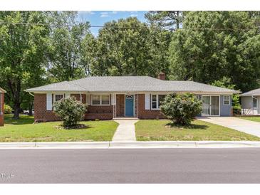 Charming single-story brick home featuring a well-maintained front yard and a bright blue front door at 408 N Stewart St, Clayton, NC 27520