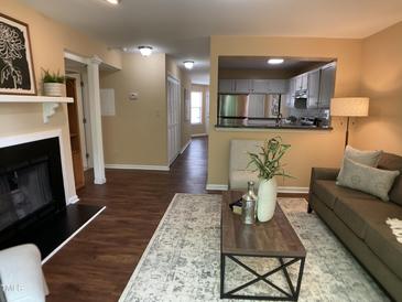 Inviting living room featuring fireplace, modern decor, and an open view to the kitchen at 600 Audobon Lake Dr # One B21, Durham, NC 27713