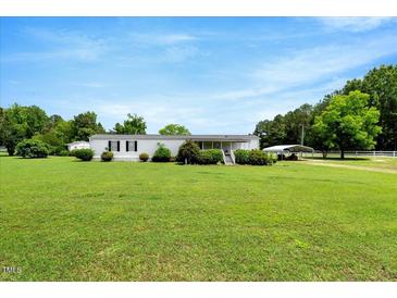 Sprawling front yard and exterior view of a single story home with covered parking at 70 Fieldside Dr, Louisburg, NC 27549