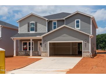 Charming two-story home featuring a two-car garage and classic gray siding at 744 Deschutes Dr, Garner, NC 27529