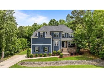 Charming two-story home with a manicured lawn and mature trees offering shade and curb appeal at 8304 Southmoor Hill Trl, Wake Forest, NC 27587