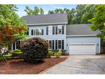 Charming two-story home with a manicured lawn, a two-car garage, and an inviting blue facade at 104 S Crabtree Knl, Chapel Hill, NC 27514