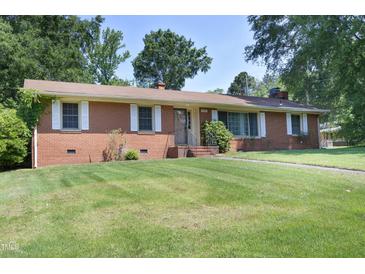 Charming single-story brick home featuring a well-maintained lawn and mature trees at 1209 Landon St, Durham, NC 27703