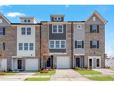 Modern townhome exterior with brick facade, attached garages, and well-maintained landscaping at 2034 Fishamble St # 30, Fuquay Varina, NC 27526