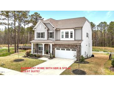 Charming two-story home featuring stone accents, gray siding, a two-car garage, and a well-manicured lawn at 3020 Mavisbank Cir, Apex, NC 27502