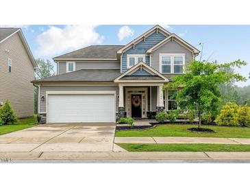 Charming two-story home featuring a two-car garage and a well-manicured lawn at 304 Avery Glenn Way, Fuquay Varina, NC 27526