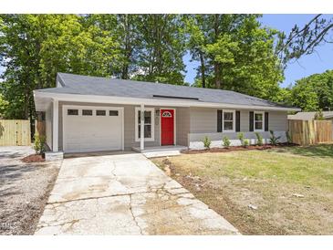 Charming single-story home features a vibrant red door and a well-manicured front yard at 3204 Winfield Ct, Raleigh, NC 27610