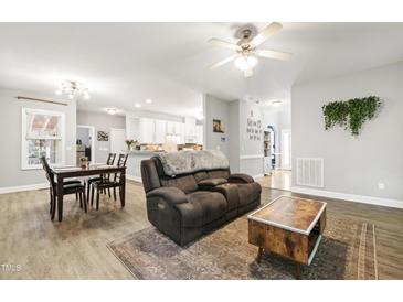 Open-concept living area showcasing a dining table, plush seating, and a view of the modern kitchen at 3821 La Costa Way, Raleigh, NC 27610