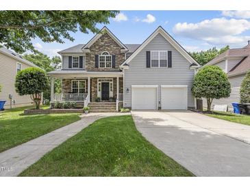 Charming two-story home features a stone facade, inviting front porch, and a well-manicured lawn at 507 Littleport Dr, Rolesville, NC 27571