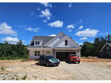 Charming new construction home with stone accents, white siding, and a two-car garage at 55 Stream View Way, Spring Hope, NC 27882
