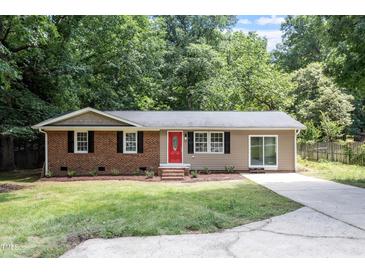 Charming single-story home with a brick facade, a red door, and a well-maintained front lawn at 7216 Carlton Dr, Raleigh, NC 27616