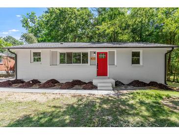 Charming single-story home featuring a bright red front door and freshly landscaped yard at 833 Brigham Rd, Raleigh, NC 27610